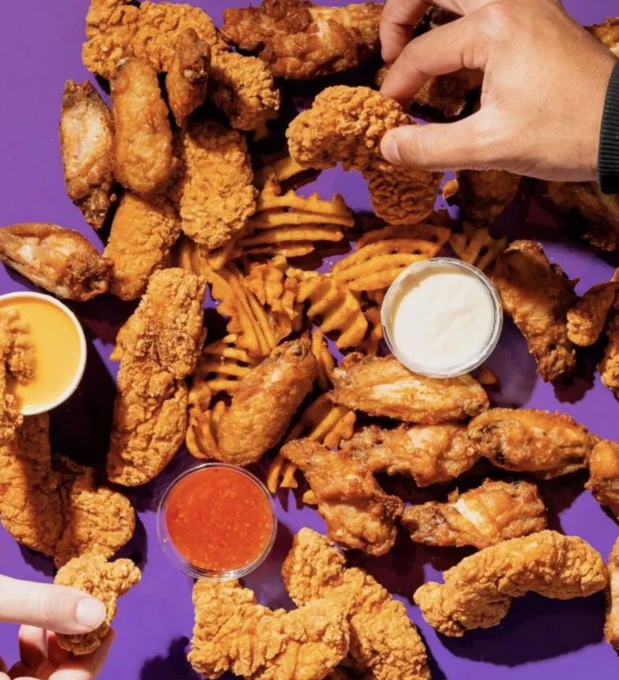 Poulet frit, tenders et ailes avec sauces, sur fond violet